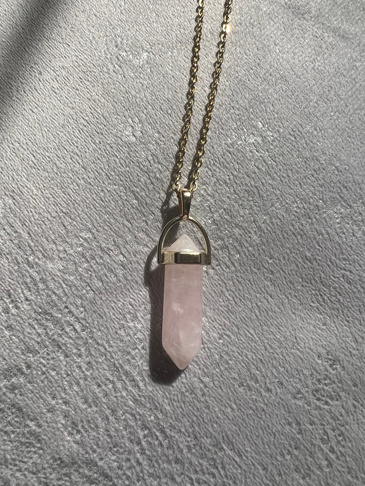 Protective Rose Quartz pendant with gold chain.