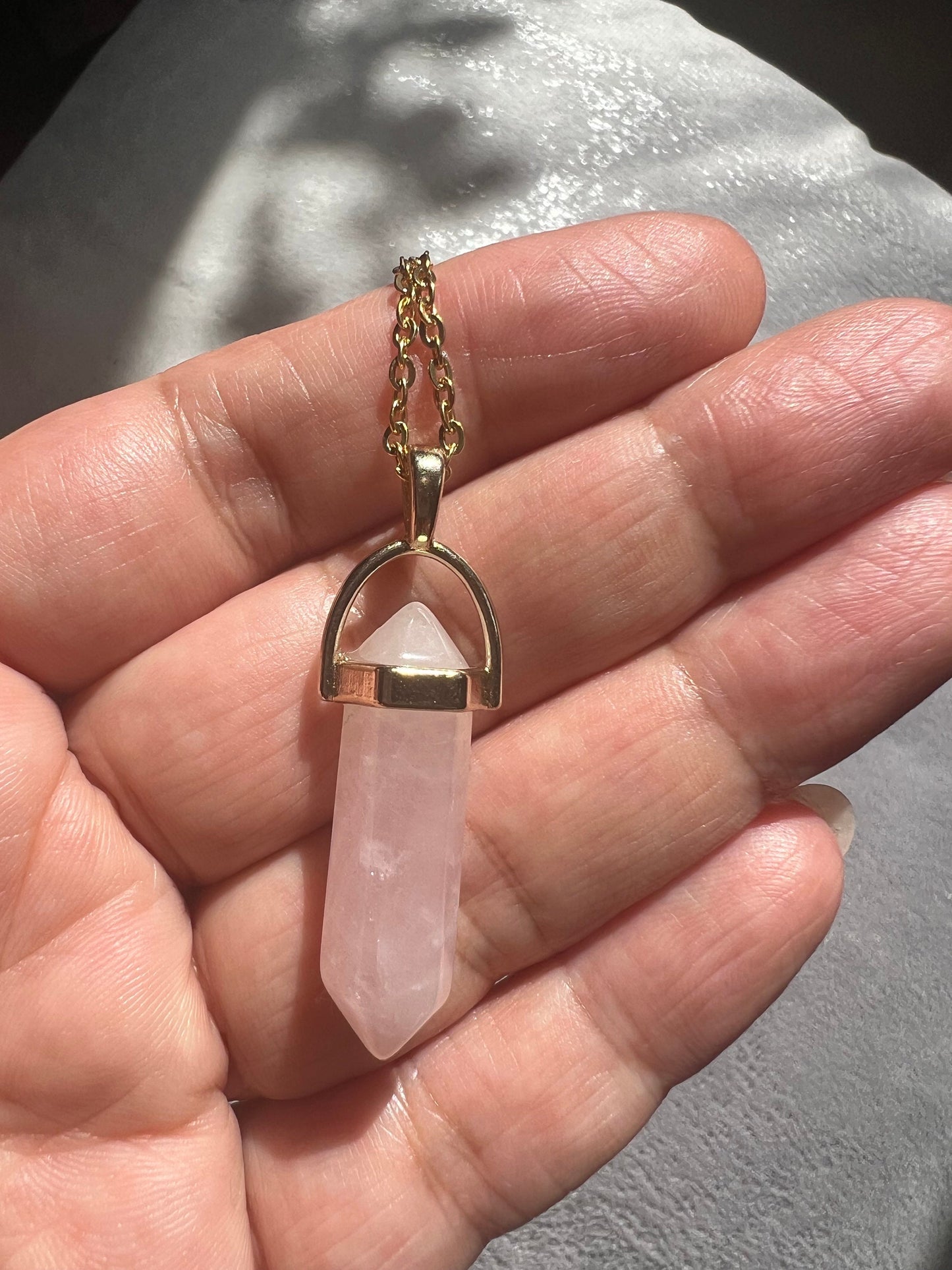 Protective Rose Quartz pendant with gold chain.